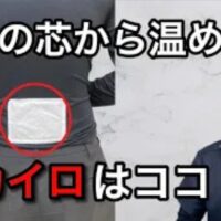 体の芯や骨の奥から冷える症状を改善するために、温める力を補充する腰のツボ「命門（めいもん）」の位置をひじの高さから正確に探し出し、カイロを横向きに貼るポイントを実演する石丸院長
