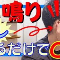 周囲で音が鳴っていないのに耳の中で雑音が響く耳鳴りを改善するために、親指と人差し指で耳全体をつまんで大きく前後10回ずつ回し耳周りの血流を引き上げるセルフケアを実演して解説する石丸院長